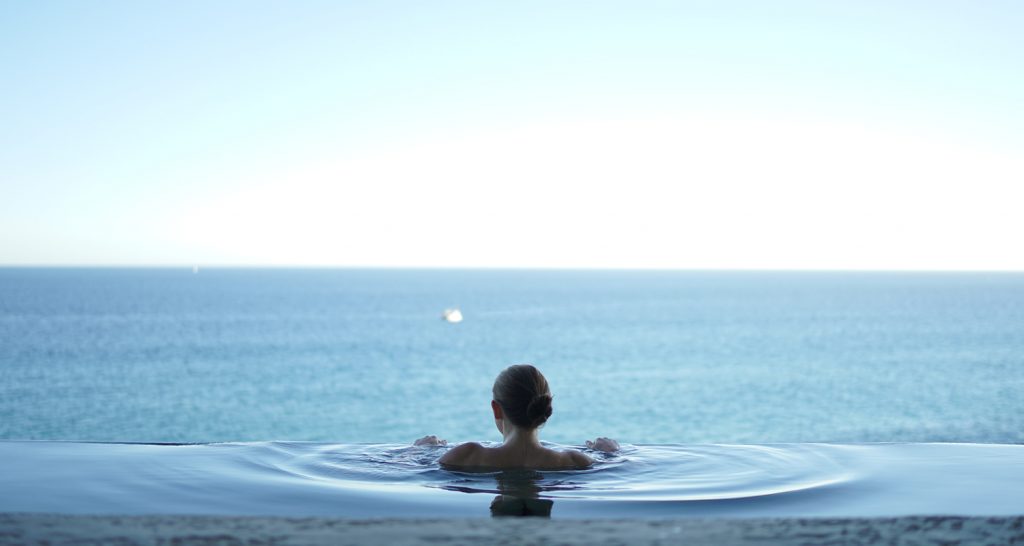 Femme se baigne dans une piscine extérieure