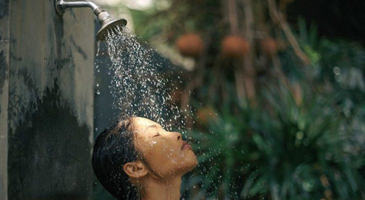 Woman takes a shower outdoors